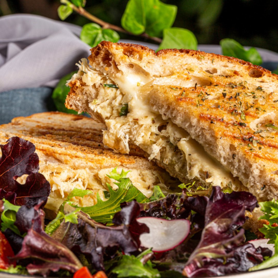 Tosta grelhada com salada sobre folhas verdes